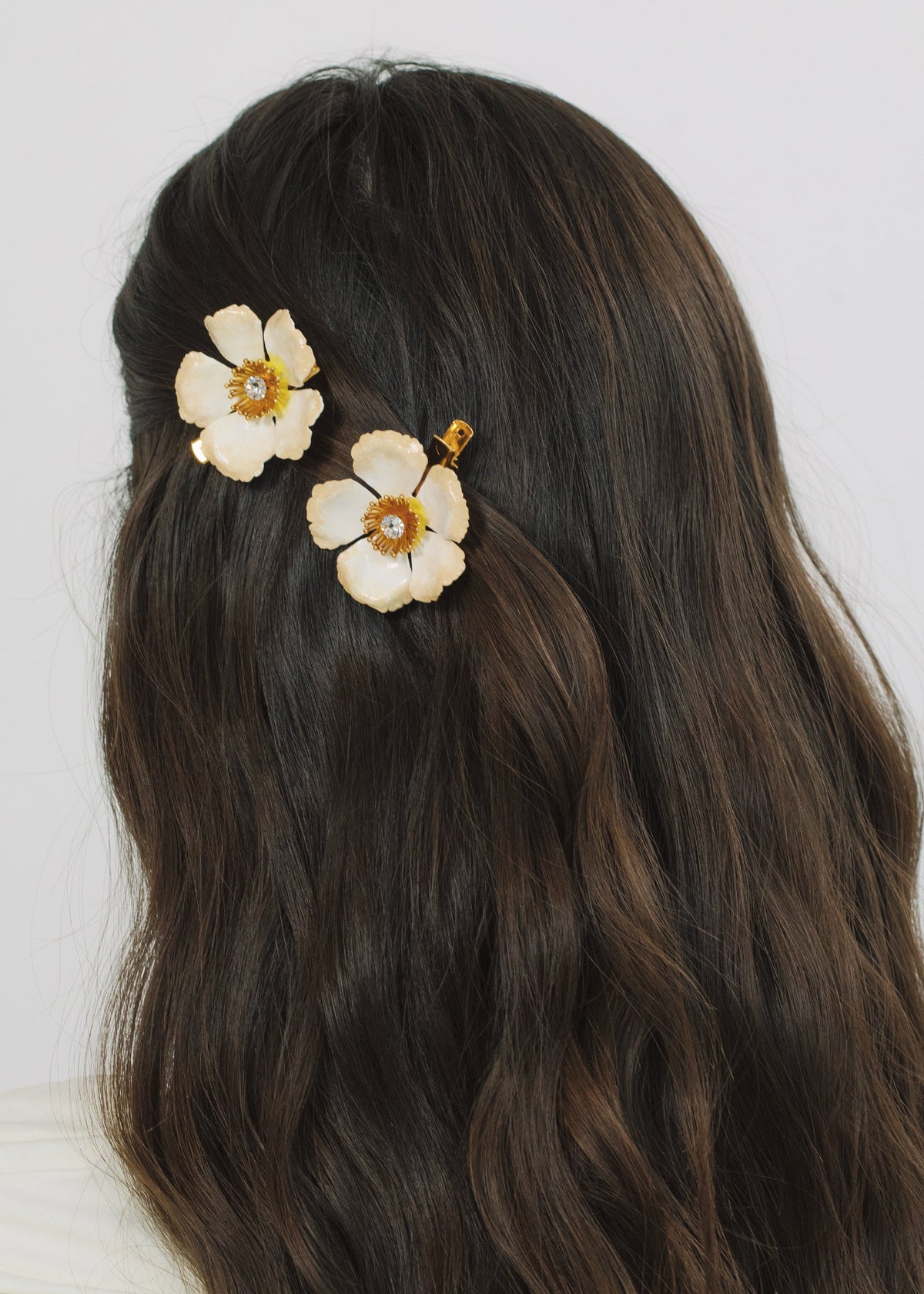 Close-up view of Debreanna Hair Clips in Champagne showcasing two hand-painted flowers with crystal centers on dark hair