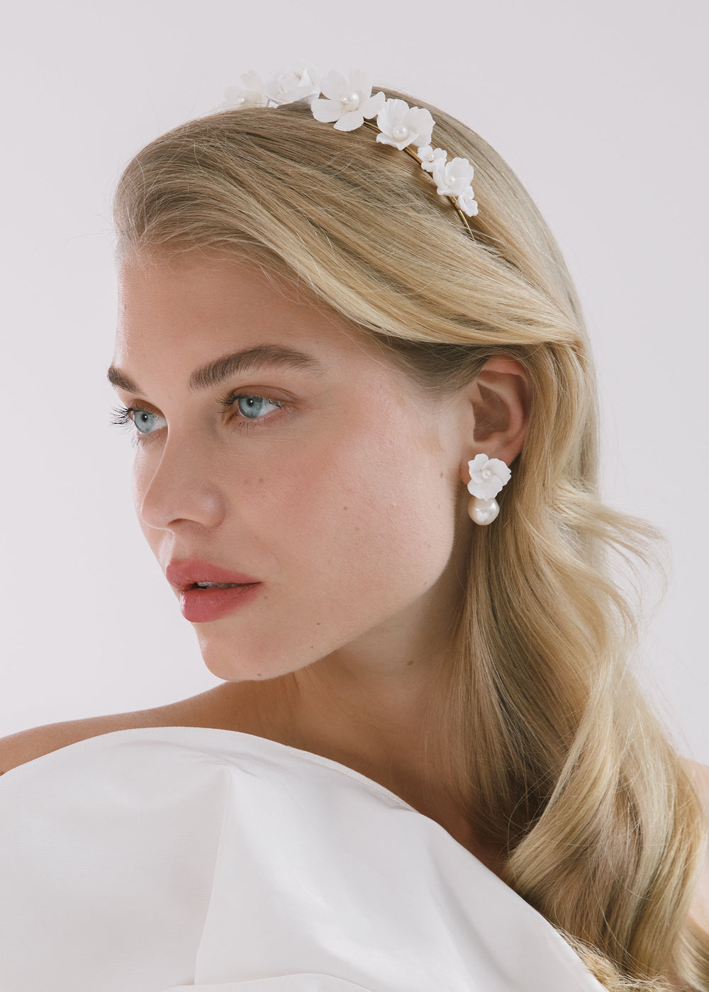 Side profile of model wearing Karissa Headband in cream with white floral appliques and pearl accents