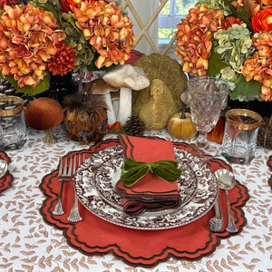 An autumn-themed table setting featuring burnt orange scalloped placemats and  matching napkins with brown embroidery, Thanksgiving table, luxury placemats