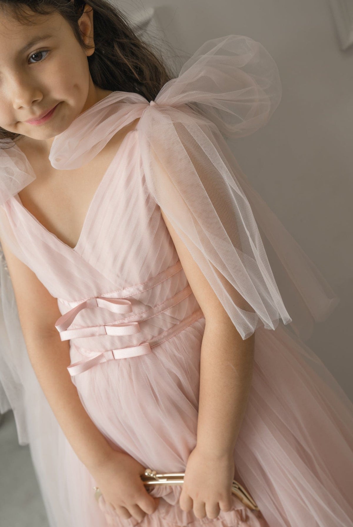 Camila Light Pink Tulle Gown detail showing V-neck bodice, sheer flutter sleeves, and elegant blush pink tulle texture.