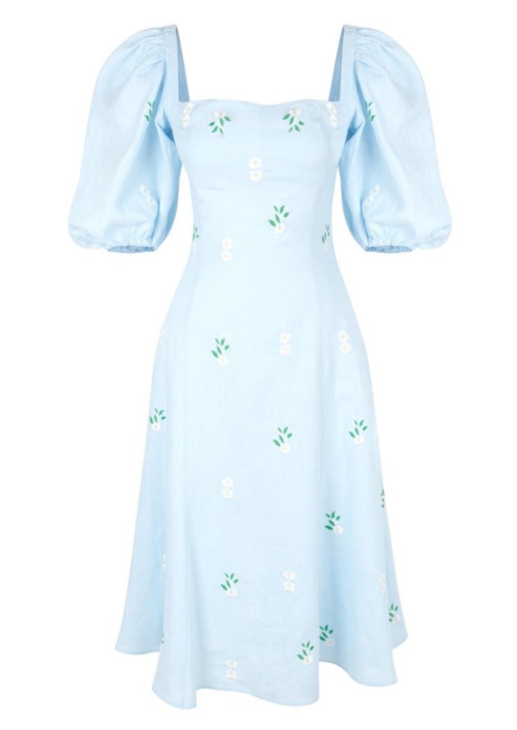 Front view of Savannah midi dress with puff sleeves, square neckline, flared skirt and daisy embroidery on light blue