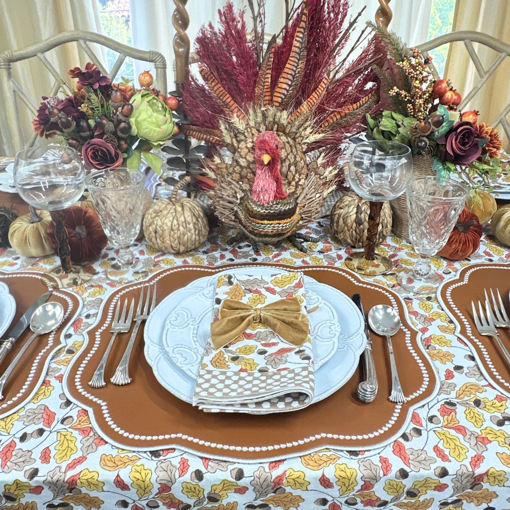 Top view of Acorns and Leaves tablecloth showcasing hand block printed amber, russet, and gold leaves and acorns with autumn place settings