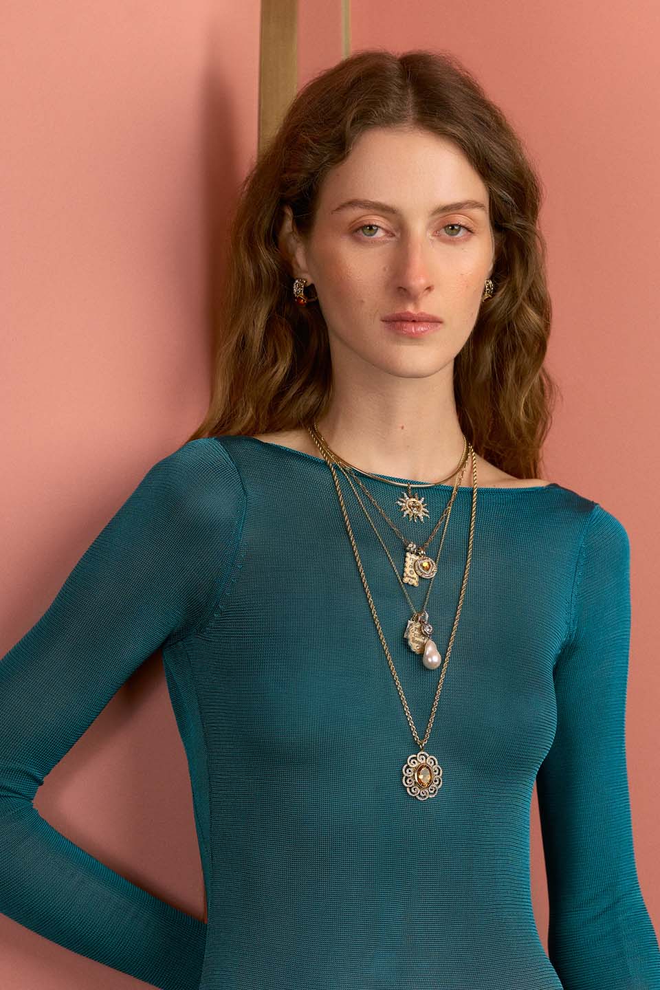 Front view of Sol Oriente Collar, 15-inch 14K yellow-gold sunburst pendant with diamonds against pink background