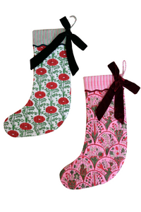 Blockprint holiday arch stockings with red floral pattern, black velvet bow, pink decorative pattern