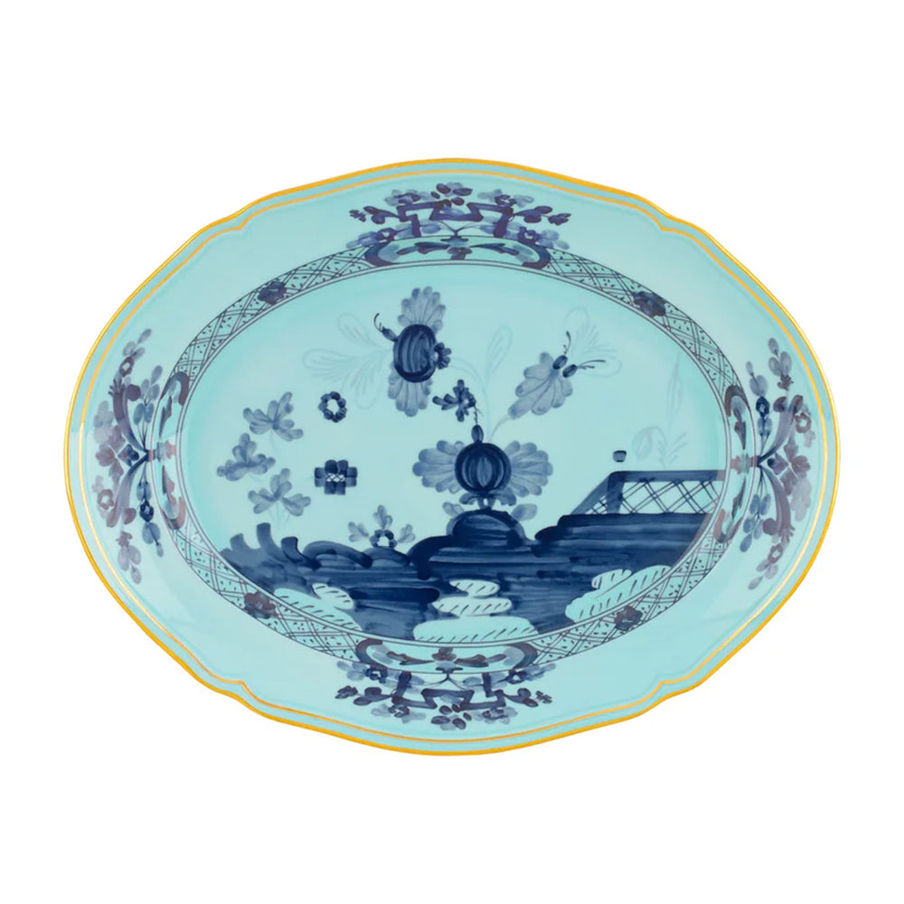 Top view of Oriente Italiano oval platter showcasing hand-painted blue floral motif and gold rim on white background
