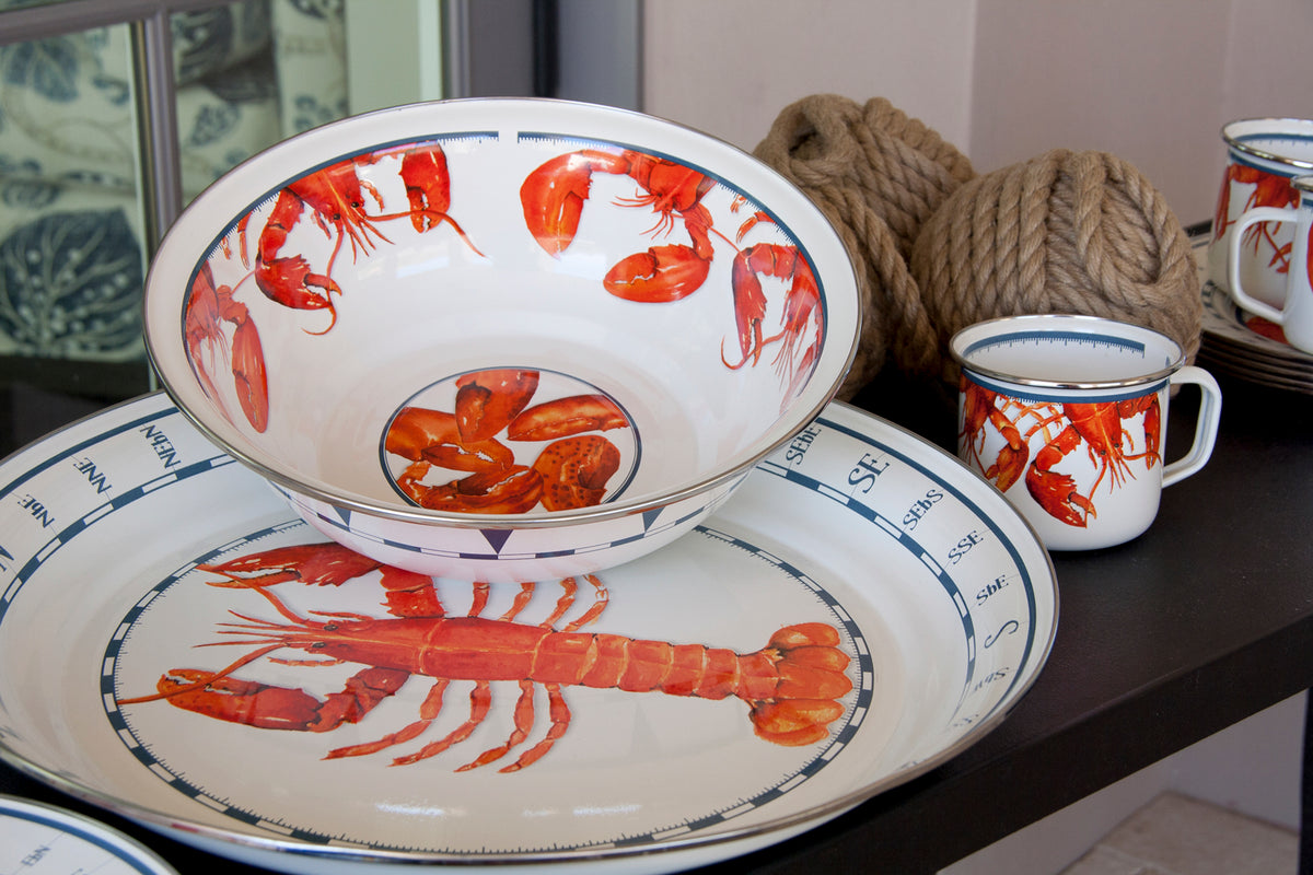 Angled view of Serving Bowl in Lobster showcasing red lobster motif inside and stainless steel rim on dark shelf with matching mug