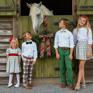 Children pose with a horse outside a barn, including a boy wearing a green bow tie