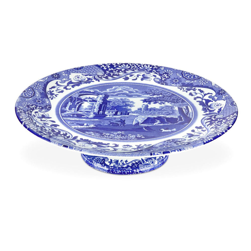 Angled top view of Blue Italian footed cake plate showcasing blue-and-white scenic pattern and pedestal base on white background