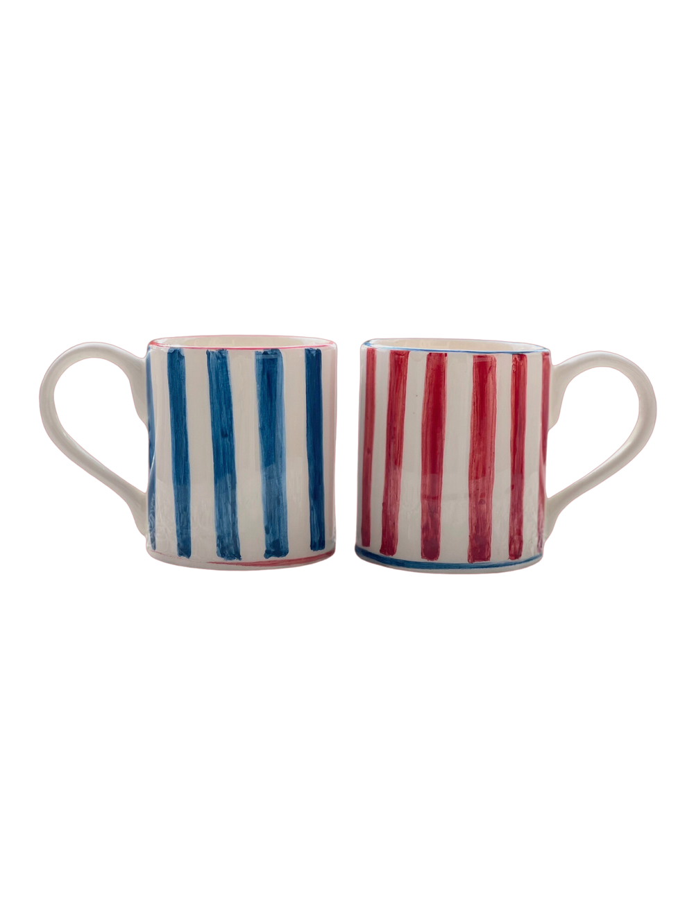 Front view of two ceramic mugs with hand-painted vertical stripes, one blue and one red, handles facing outward on plain background