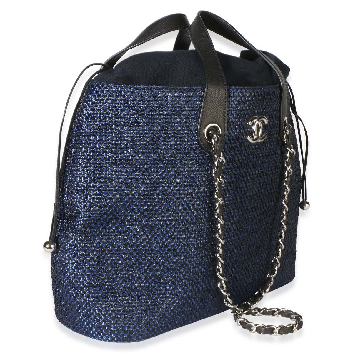 Front three-quarter view of Chanel Navy Blue Raffia CC Expandable Shopping Tote showcasing raffia, silver-tone hardware, and drawstring closure