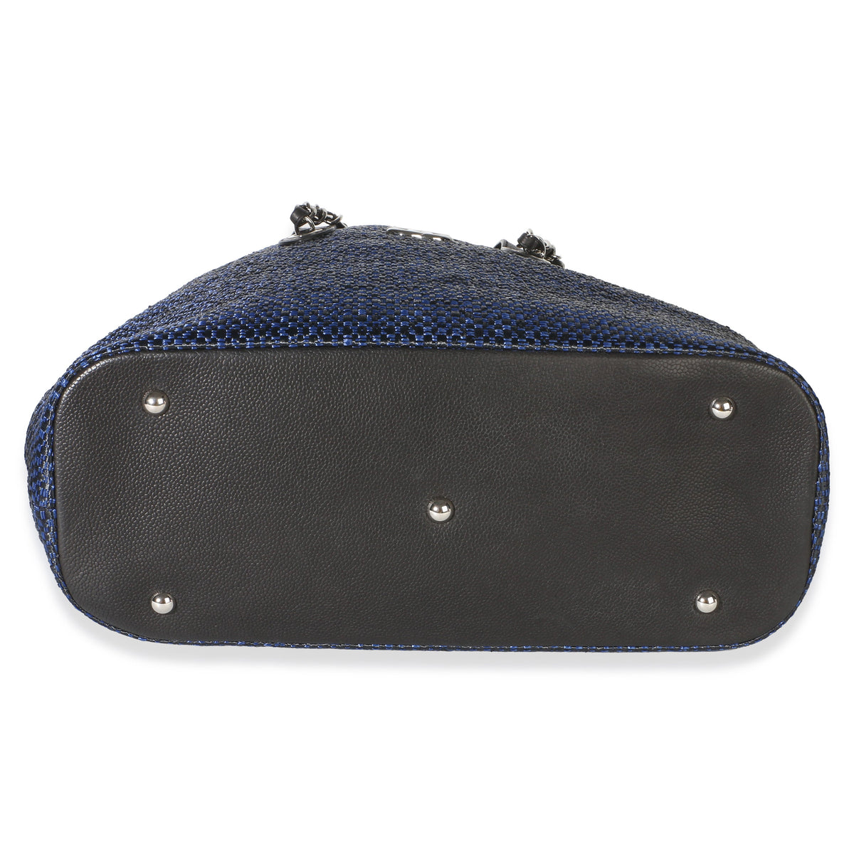 Bottom view of Chanel Navy Blue Raffia CC Expandable Shopping Tote showcasing silver tone feet and blue raffia exterior on white