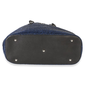 Bottom view of Chanel Navy Blue Raffia CC Expandable Shopping Tote showcasing silver tone feet and blue raffia exterior on white