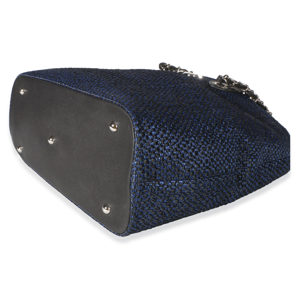 Bottom view of Chanel Navy Blue Raffia CC Expandable Shopping Tote showcasing navy blue raffia, dark base, and silver-tone feet on white
