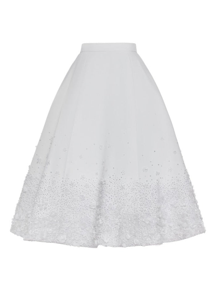 Front of The Tara Skirt showing A-line shape with hand-embroidered pearls and fabric flowers at hem on white background