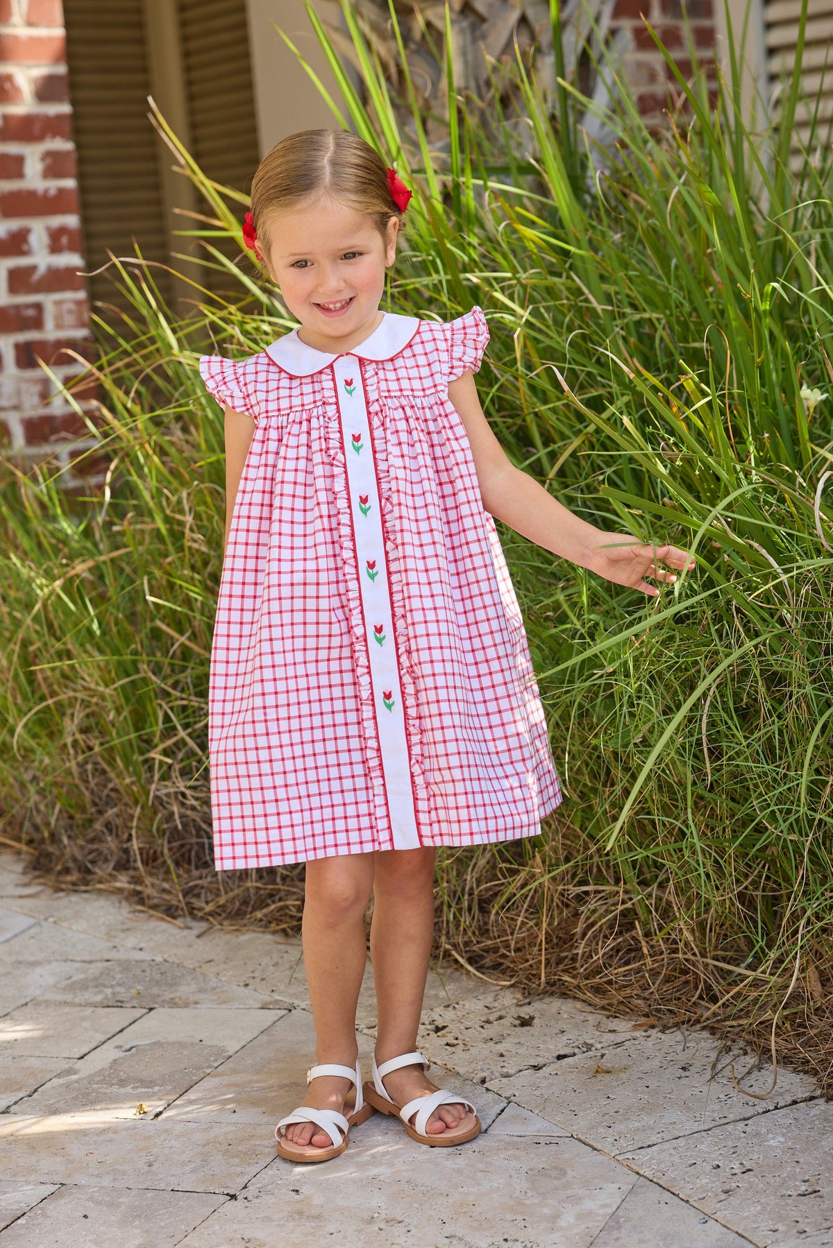 Little English traditional children's clothing. Classic dress for toddler girls in red windowpane with peter pan collar and tulip embroidery