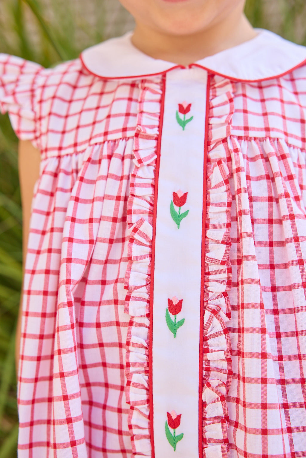 Little English traditional children's clothing. Classic dress for toddler girls in red windowpane with peter pan collar and tulip embroidery