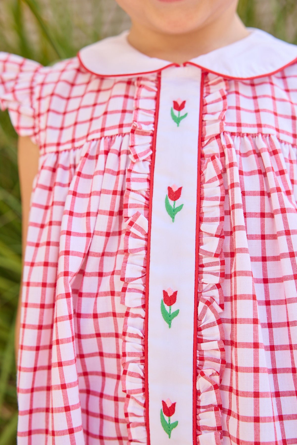 Little English traditional children's clothing. Classic dress for toddler girls in red windowpane with peter pan collar and tulip embroidery