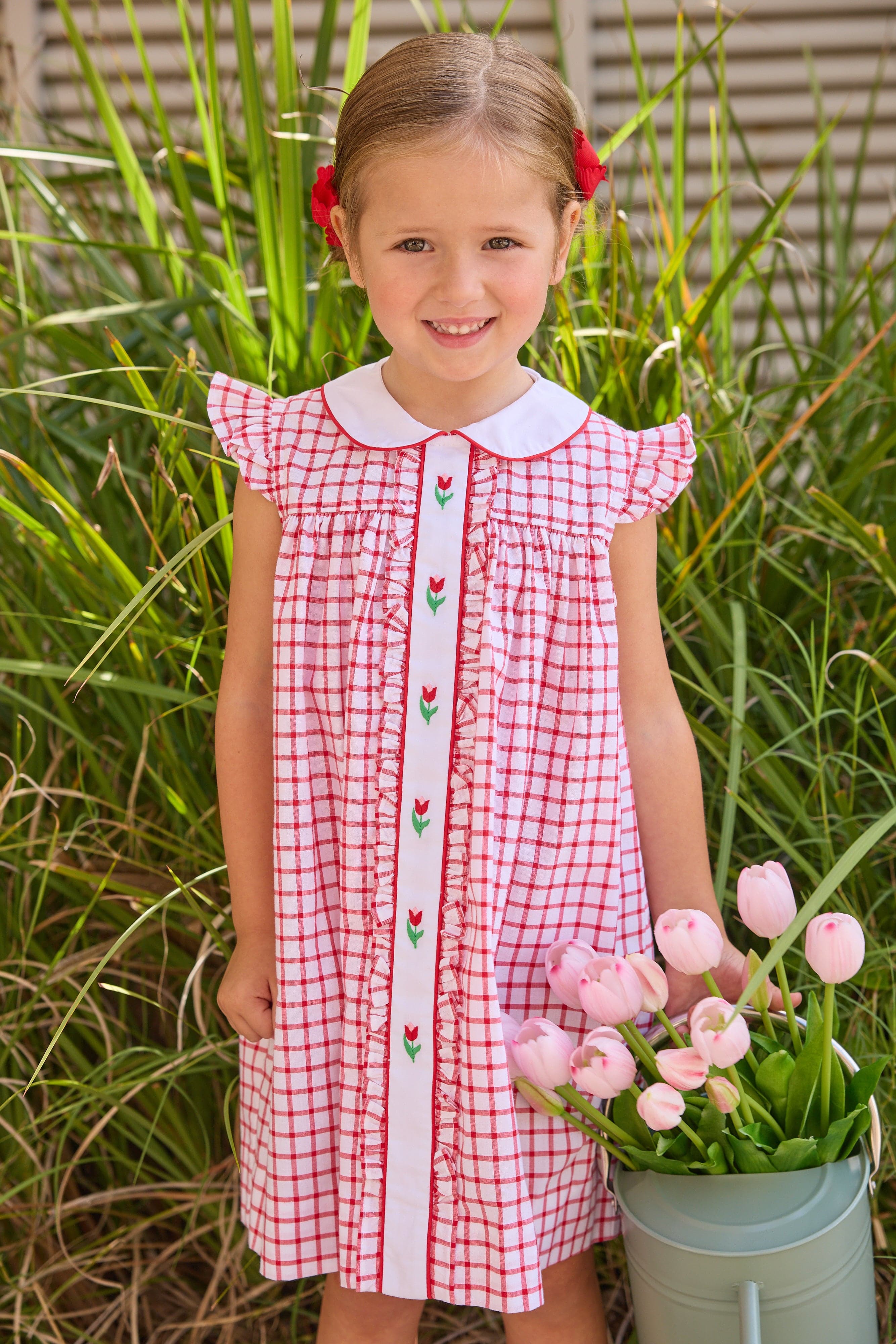 Little English traditional children's clothing. Classic dress for toddler girls in red windowpane with peter pan collar and tulip embroidery