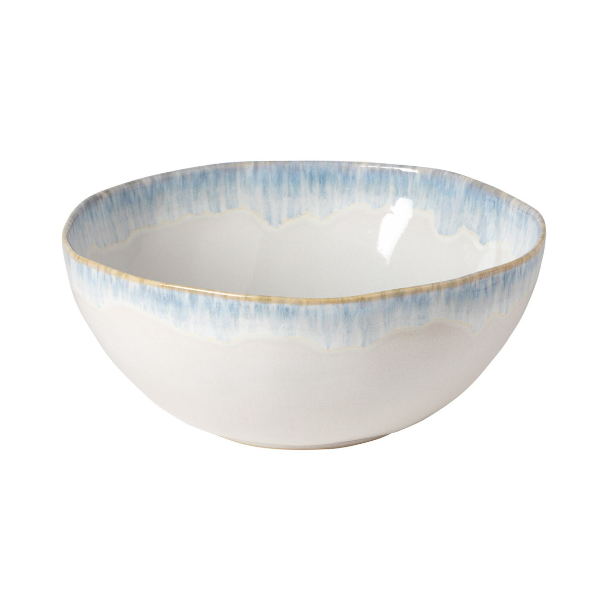 Three-quarter view of Brisa Collection serving bowl showcasing blue dripping rim glaze on white stoneware against a white background