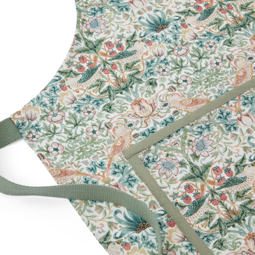 Close-up of Morris & Co. Apron showcasing its bird and floral pattern with green straps on a white background