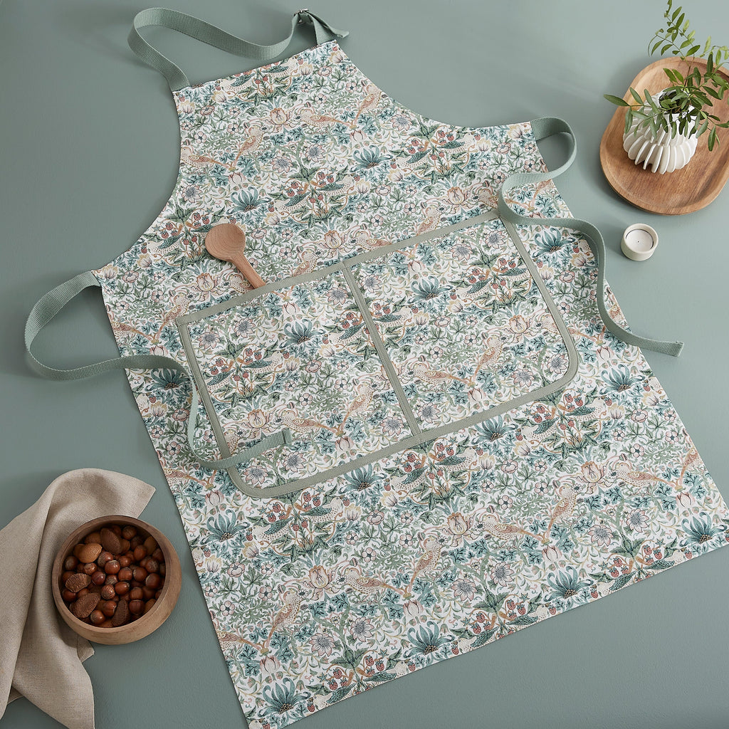 Overhead view of Morris & Co. Apron showcasing its botanical bird pattern with sage green ties on a muted green background