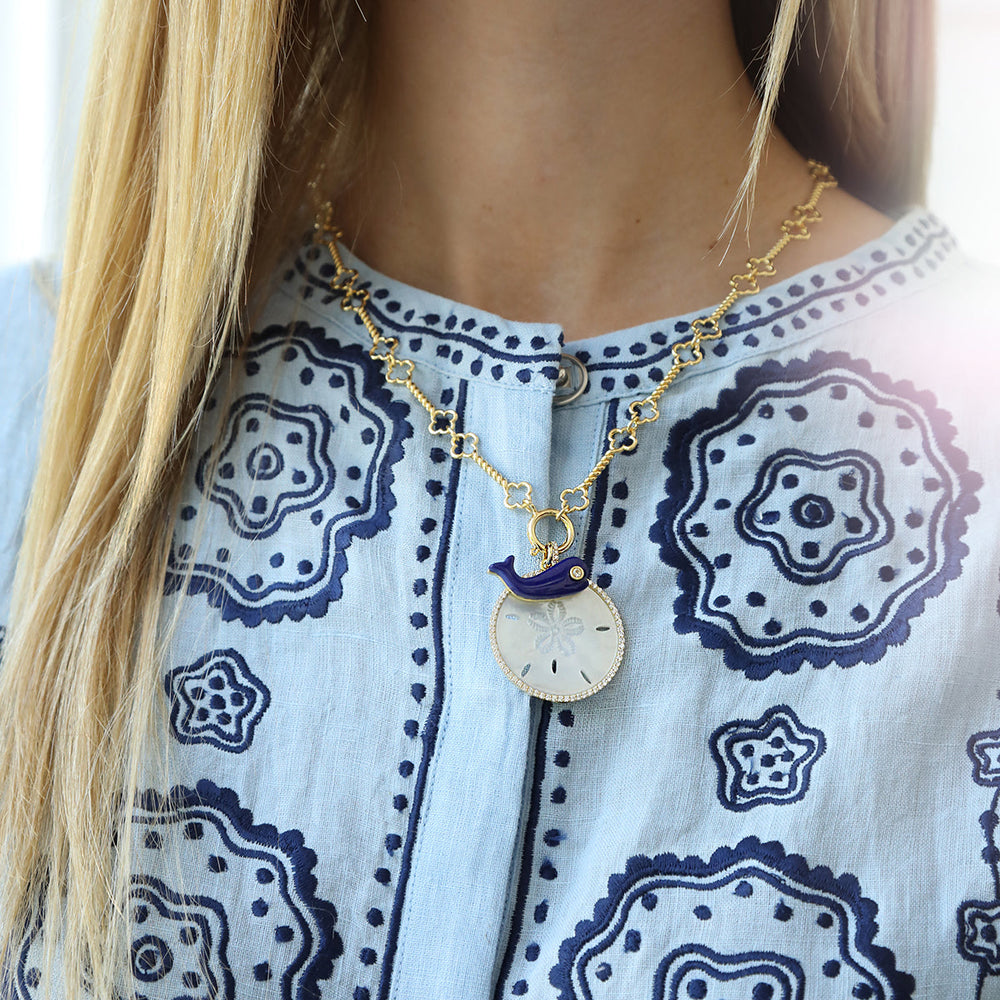 Front view of Lapis Moby Charm pendant on model showcasing deep lapis whale charm with 14K gold-dipped chain and sand dollar disc on patterned blouse