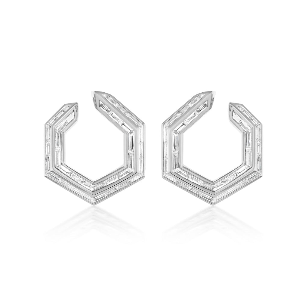 The Chrysler Front-To-Back Hoops with Baguette Diamonds are geometric hexagonal silver earrings, each edge set with small rectangular diamonds, shown on a white background.