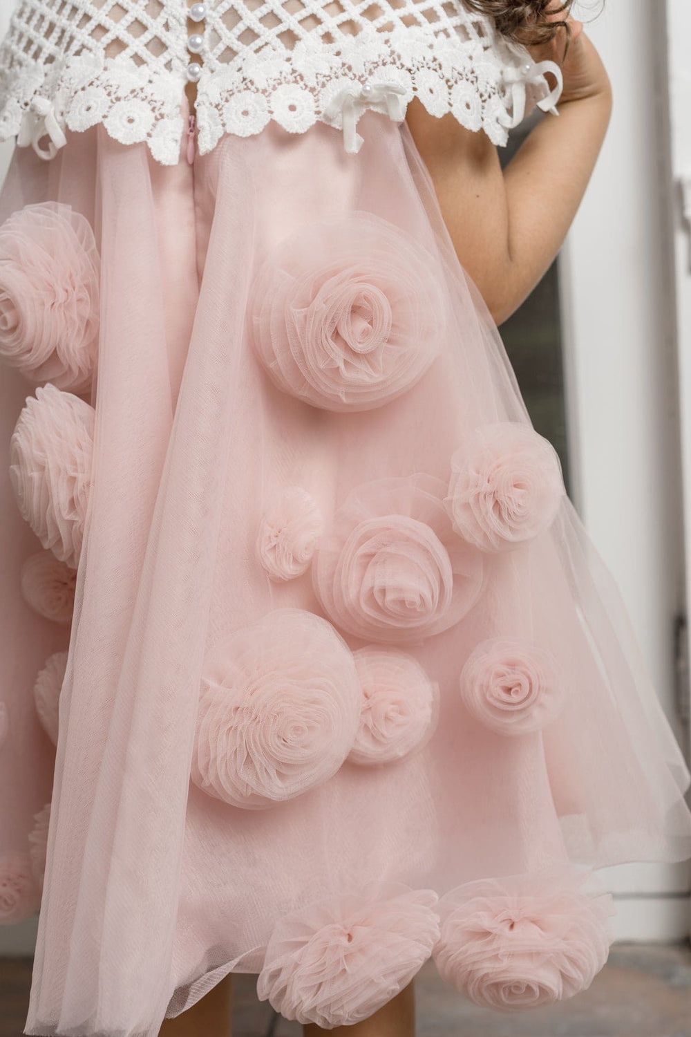 Rosa pink tulle flower dress for girls with a lace bodice, bow accents, and laser cut floral back detail, designed for elegant special occasions.