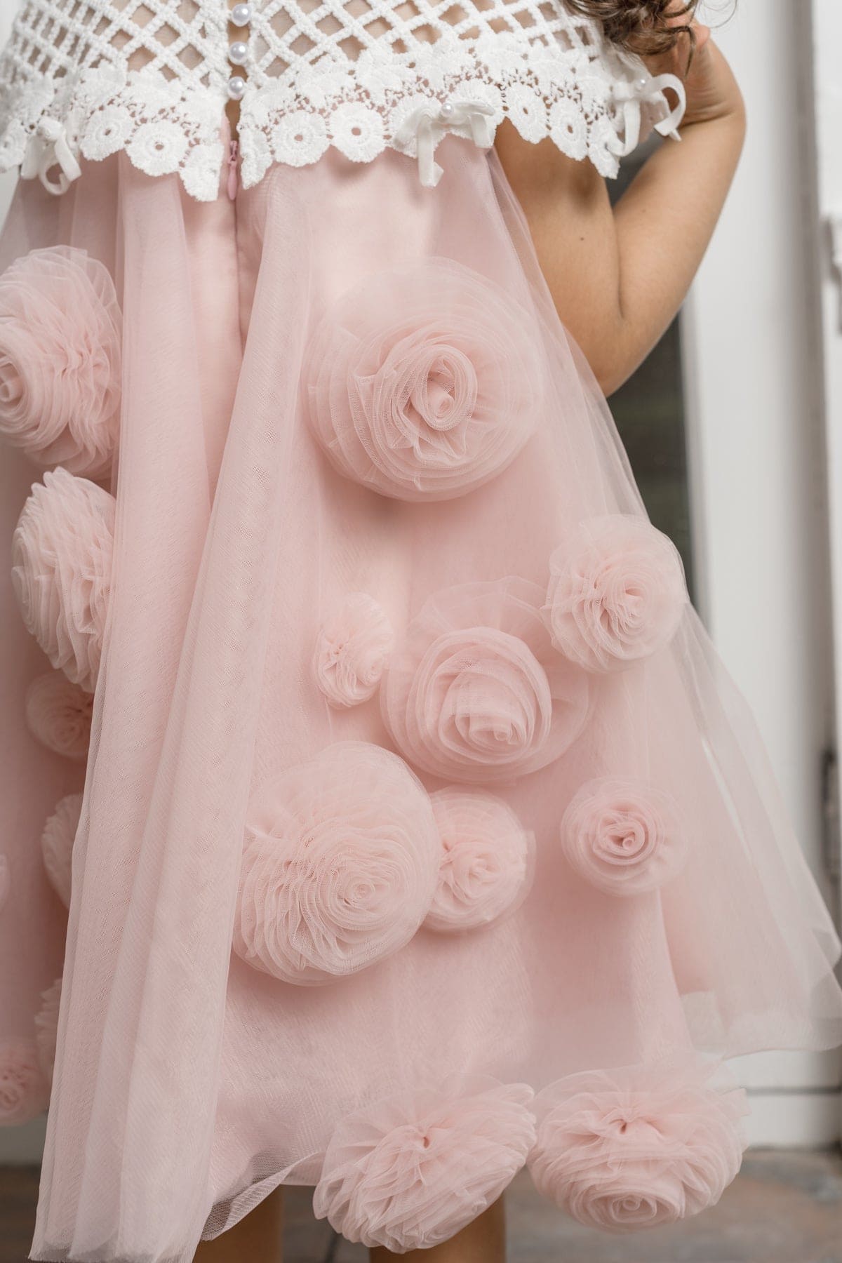 Rosa pink tulle flower dress for girls with a lace bodice, bow accents, and laser cut floral back detail, designed for elegant special occasions.
