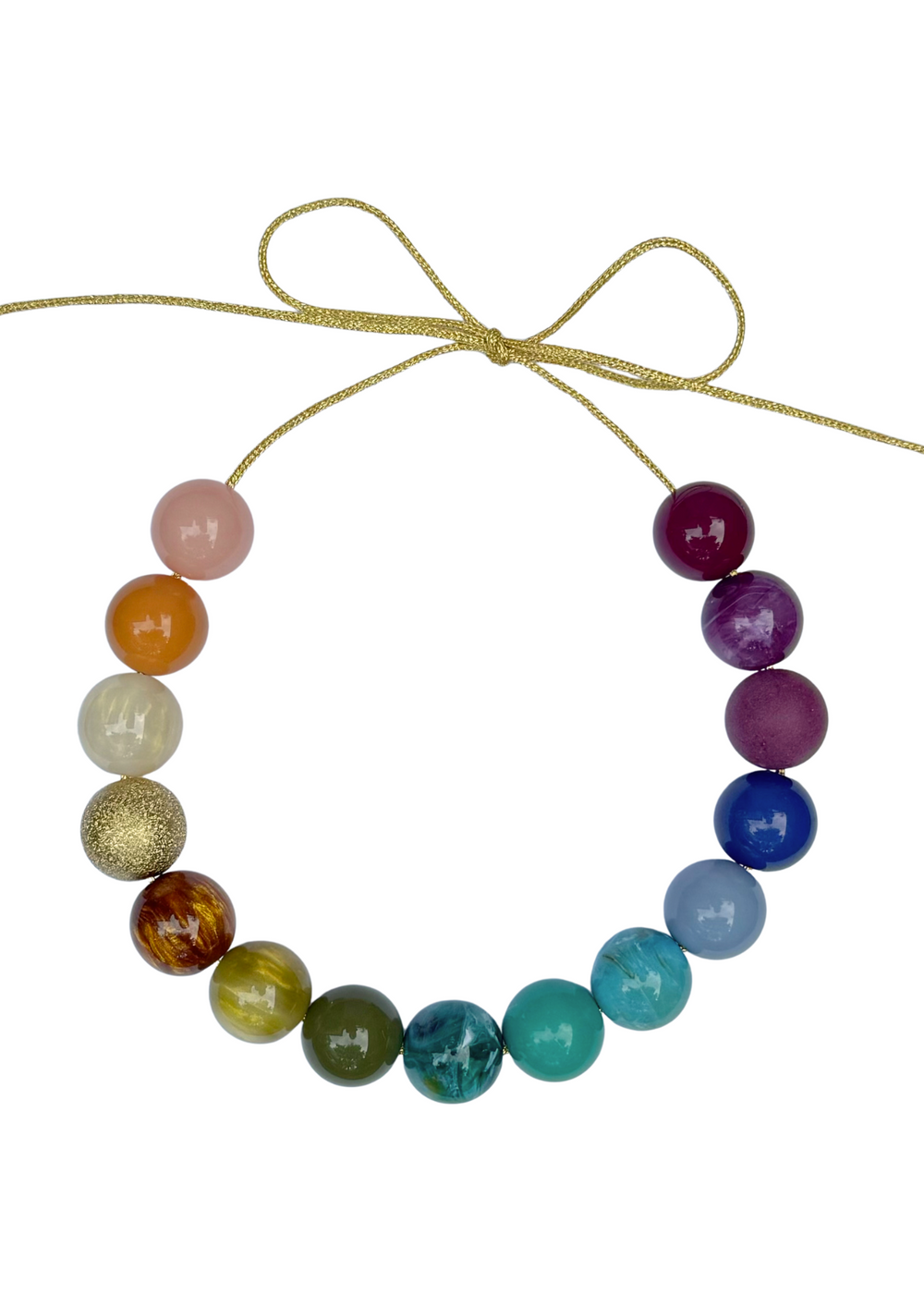 Flat lay of Central Park Bubble Necklace showcasing rainbow beads and gold lurex cord tied in a bow on white