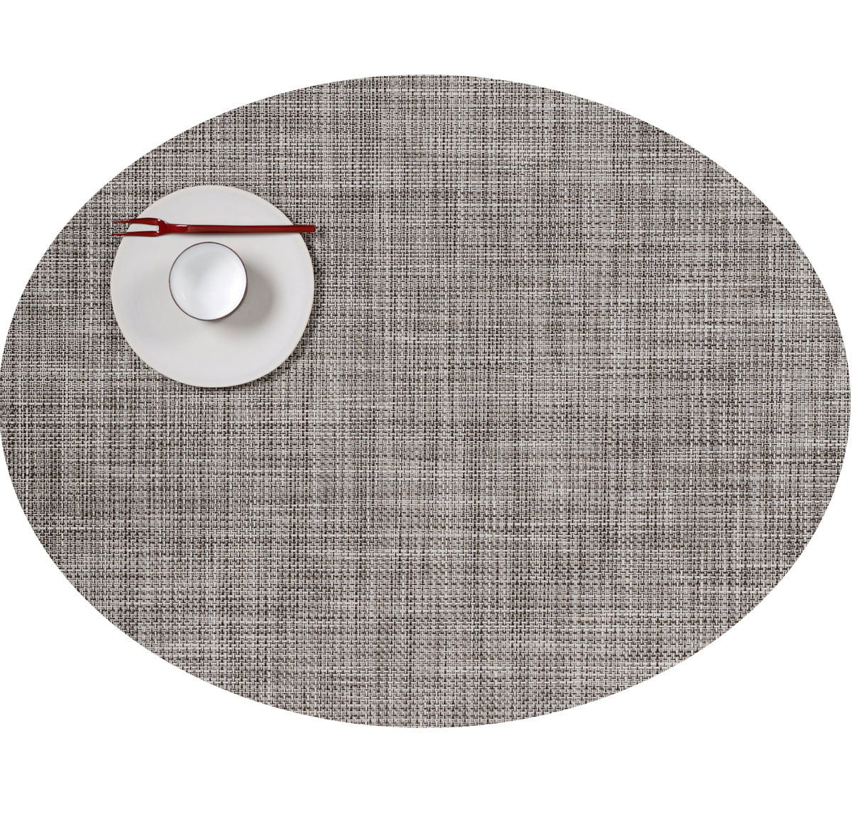Top-down view of Mini Basketweave round placemat in Gravel showing woven texture with white saucer, cup, and red chopsticks