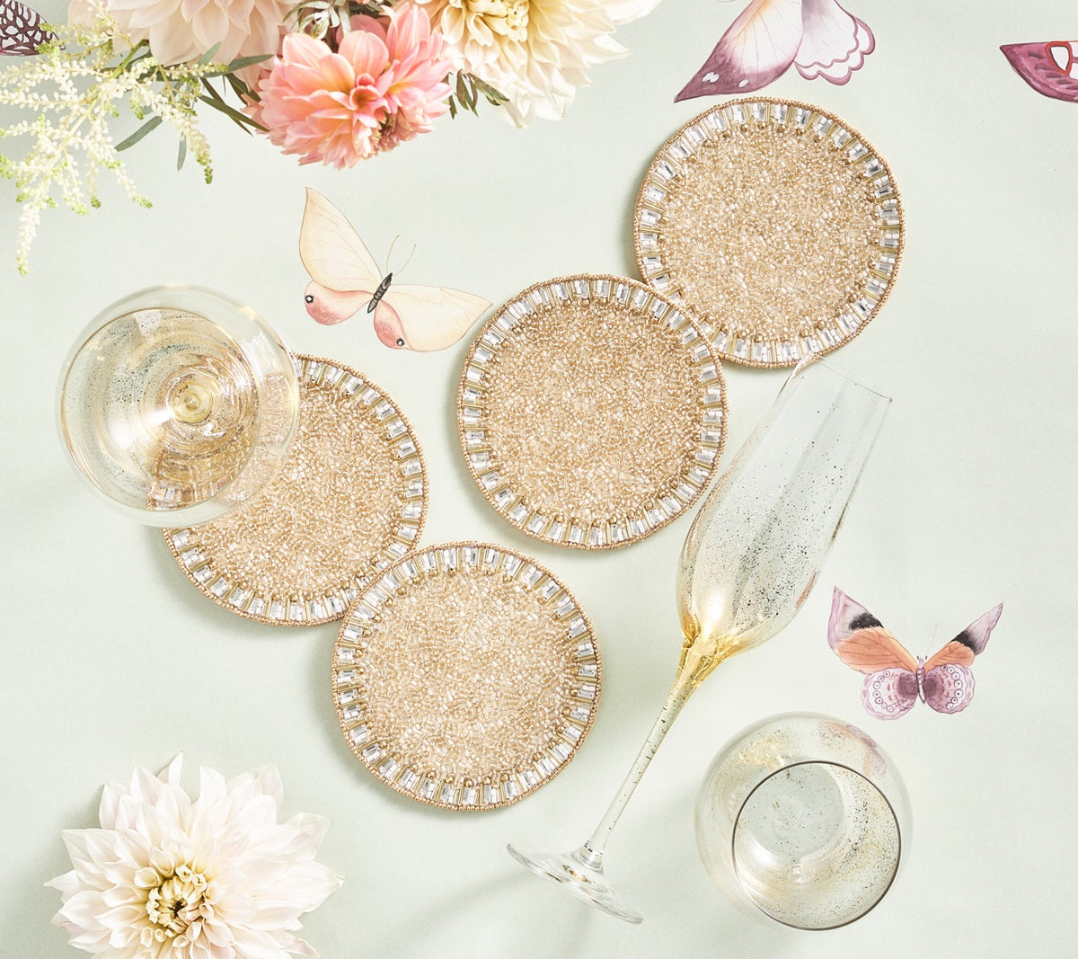Top view of Bevel Drink Coasters in Gold and Silver, set of 4, showcasing pavé bead pattern with drinks and flowers