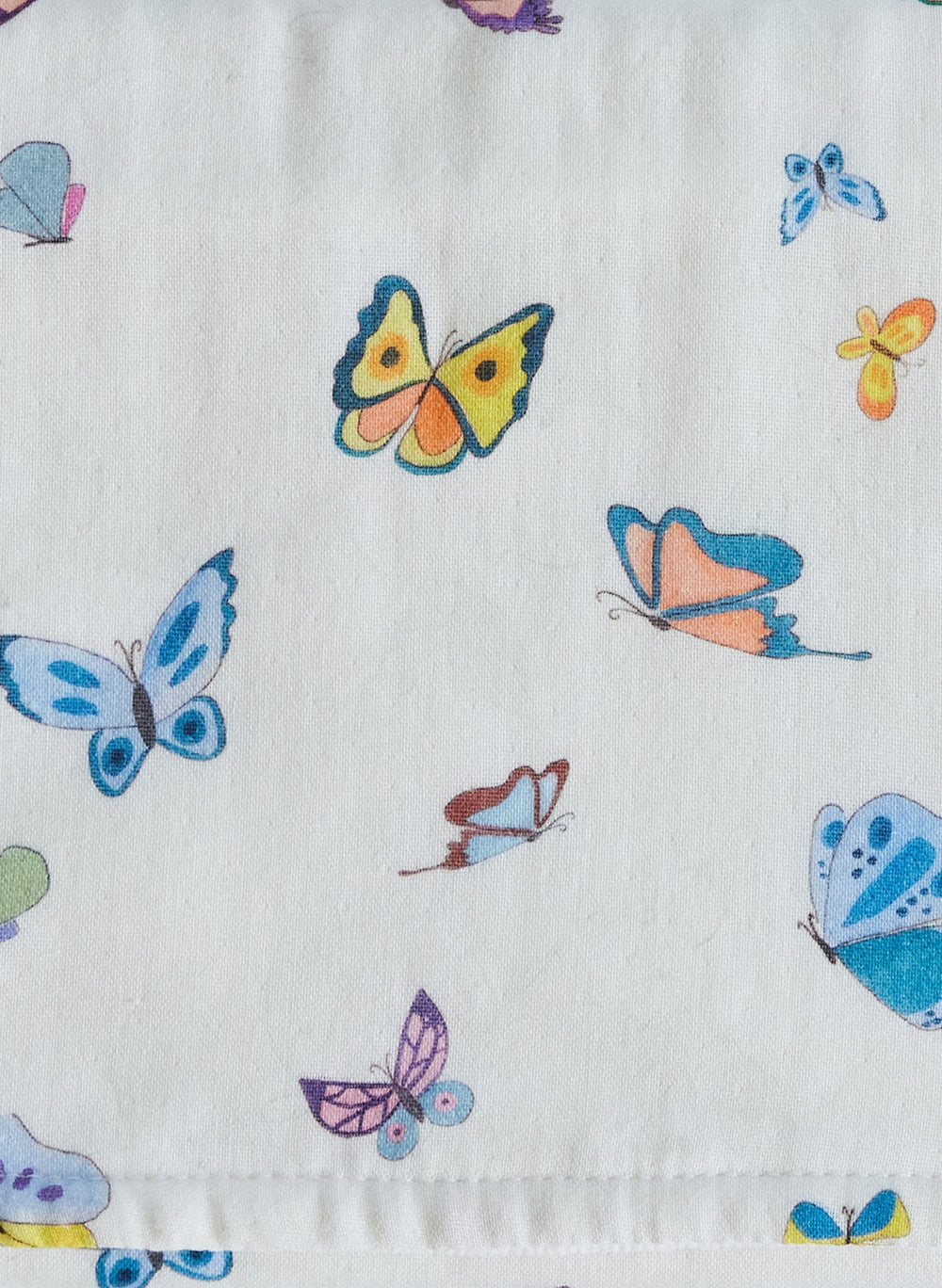 Close-up of Madame Butterfly burp cloth showing colorful butterfly print on white muslin with stitched edge