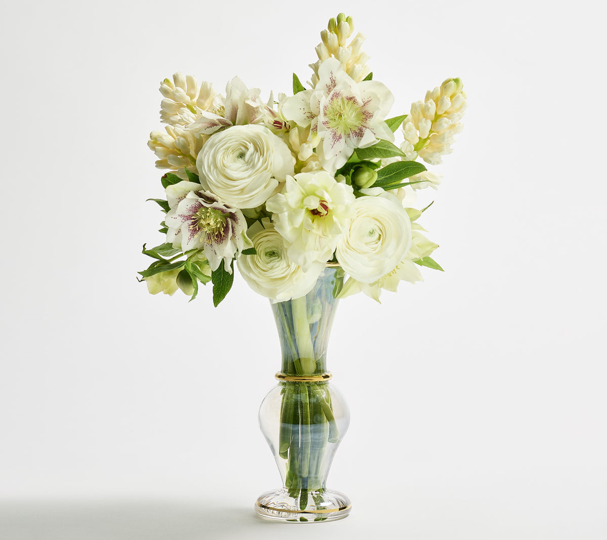 Front view of Trumpet Bud Vase in clear glass with iridescent luster and 18k gold bands holding white flowers