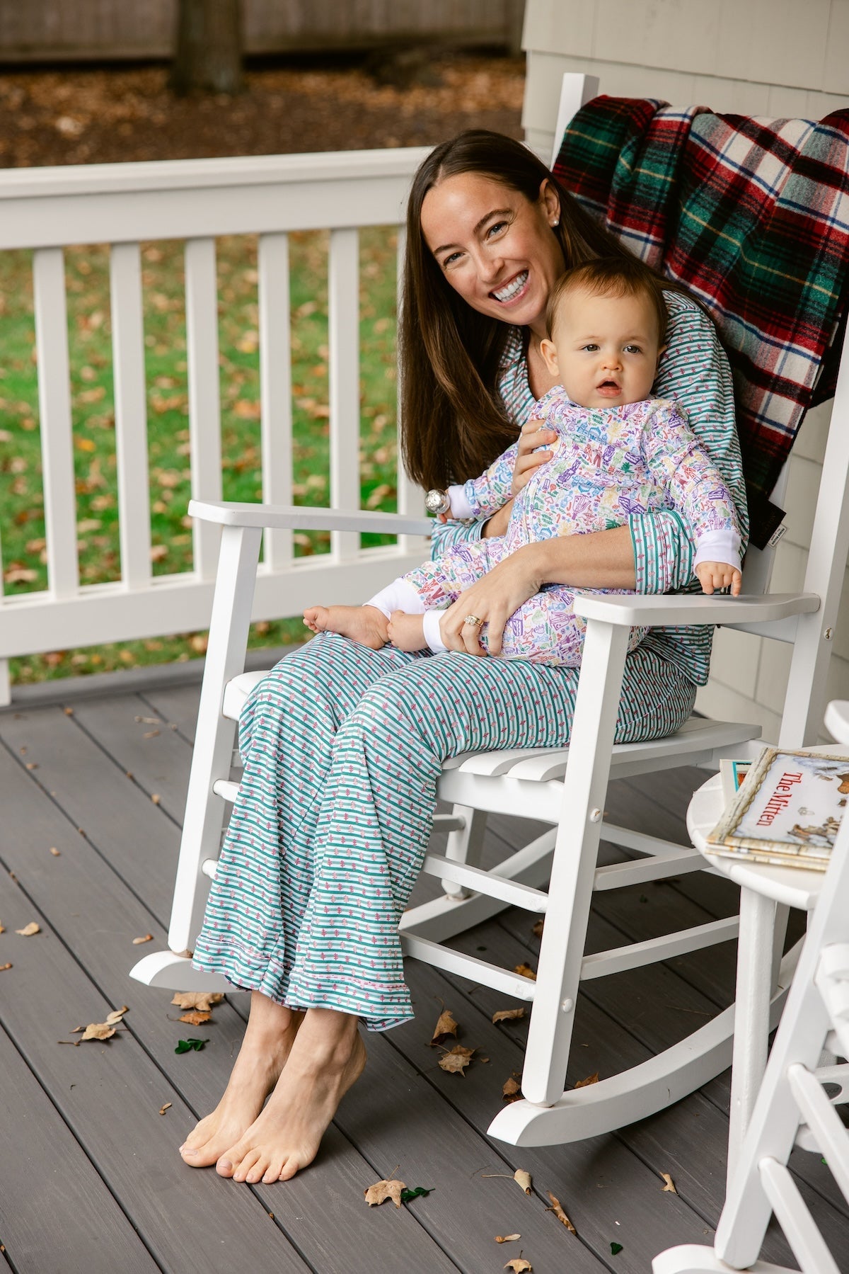Seated front view of Joy Street Hanukkah women’s button-front pajama set in green stripes showing relaxed fit on a porch