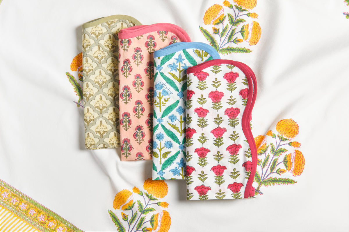 Close-up view of The Delfina Napkin showcasing colorful floral patterns on 100 percent cotton with a white background