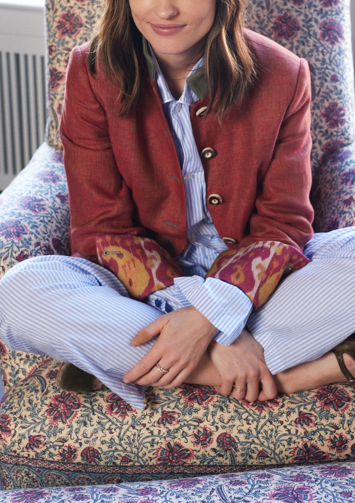 Front view of Louise Jacket in Terracotta Linen showcasing olive green collar and Ikat details on seated model