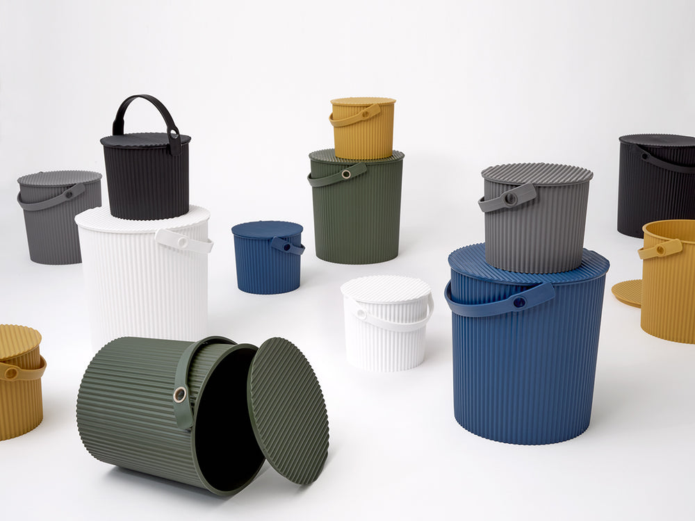 Front view of Hachiman Bucket Mini showing ribbed texture, removable lid, carrying handle, and multiple color options on a white background