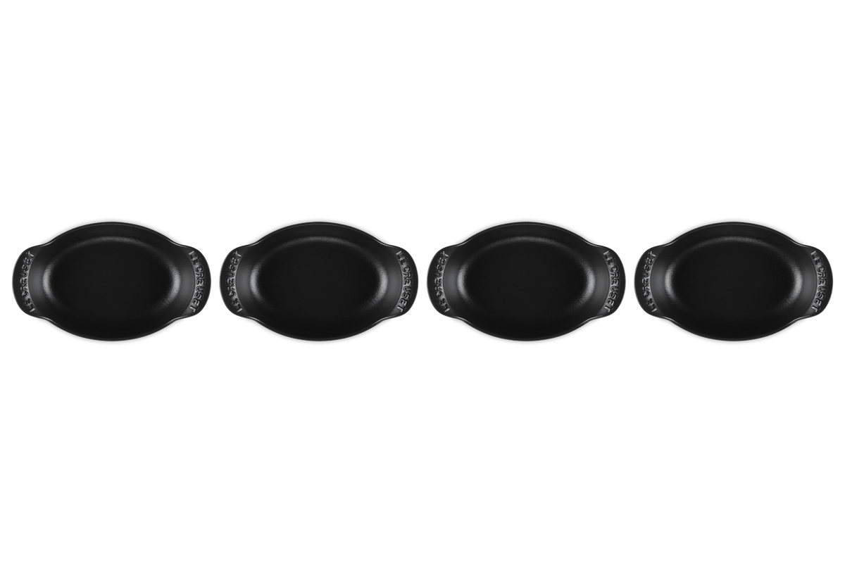 Front view of four Mini Oval Bakers showcasing matte black enamel and curved handles with a white background