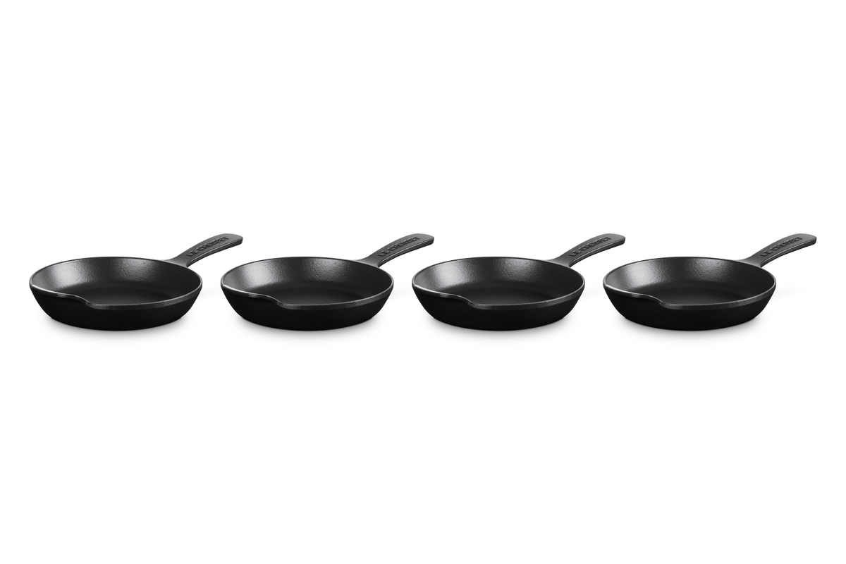Three quarter view of Mini Skillet 1/3 qt in Matte Black showcasing four skillets with white background