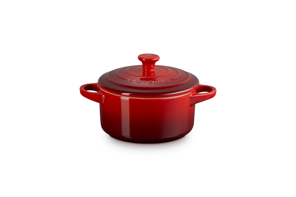 Front view of Mini Round Cocotte in Cerise showcasing its lid, side handles, and Le Creuset embossing against a gray background