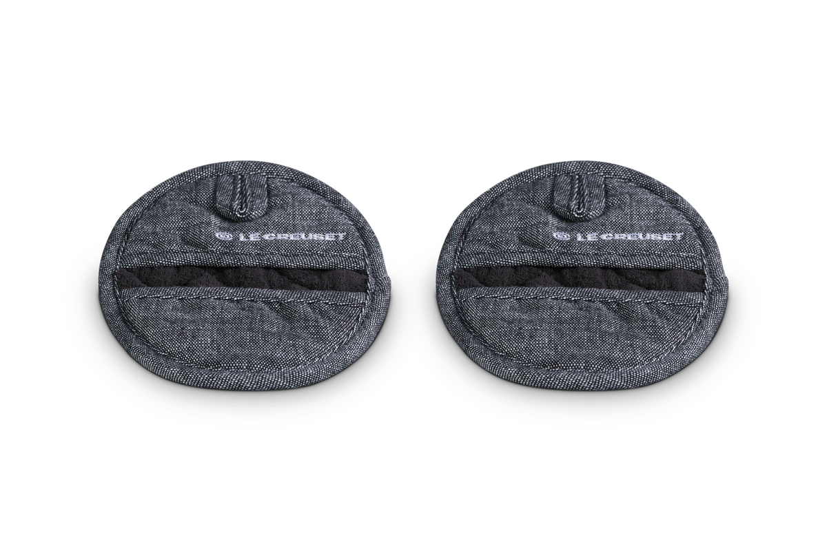 Close-up of Pot Grips Noir, Set of 2 showcasing textured heat-resistant silicone and soft terry cloth lining on white background