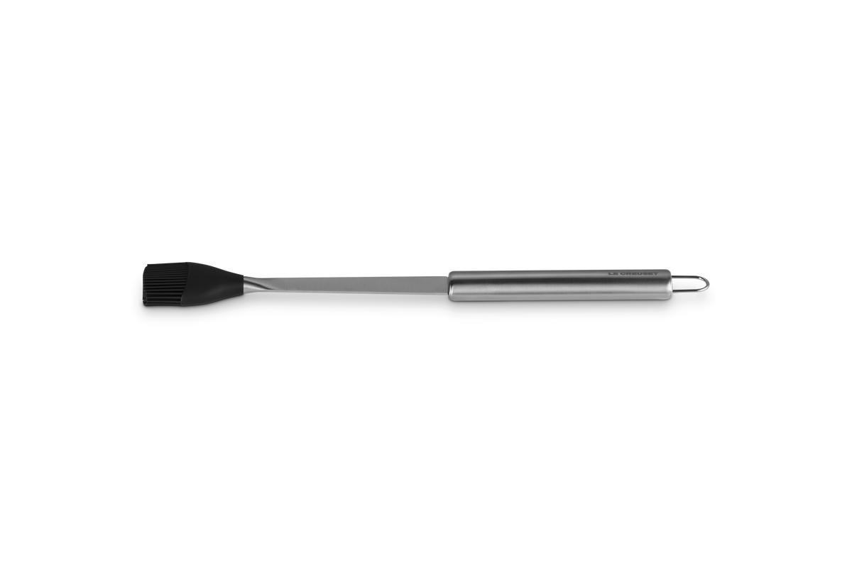 Side view of Le Creuset basting brush with long stainless handle, hanging loop, and black silicone head