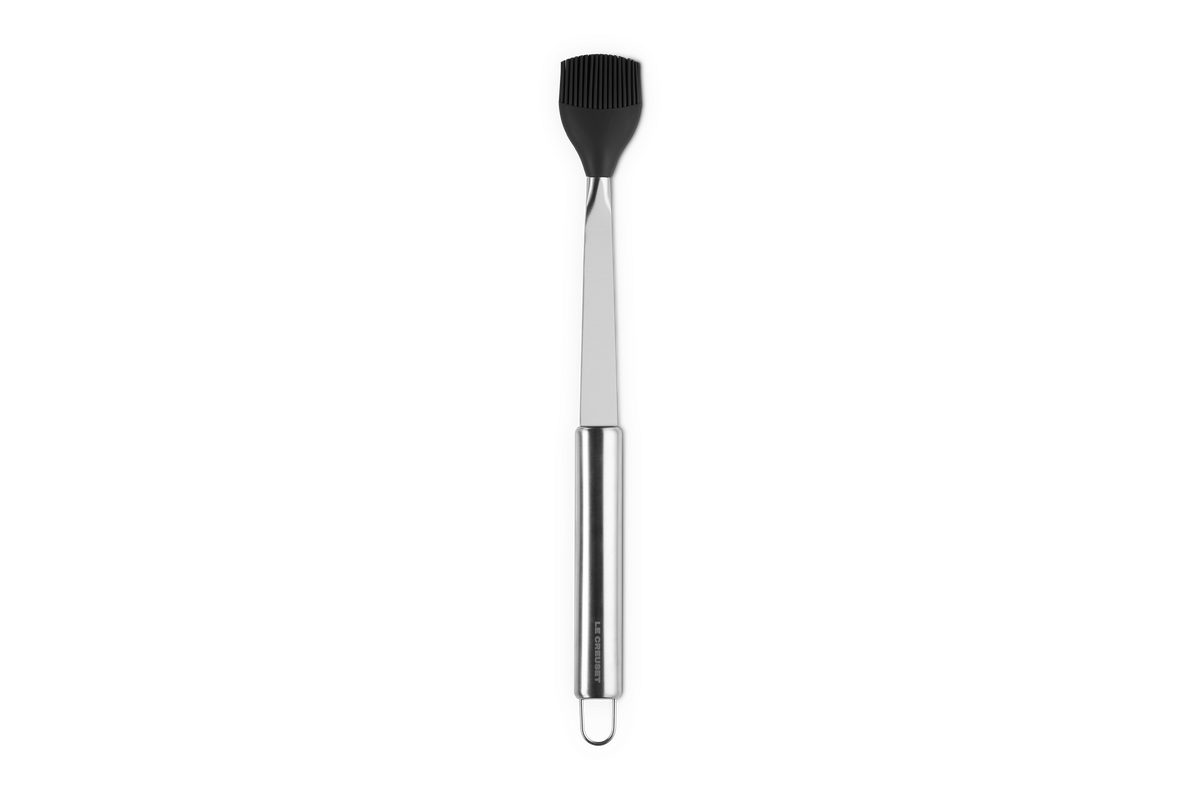 Front view of Le Creuset Basting Brush showcasing black silicone head and stainless steel handle with dark gray background