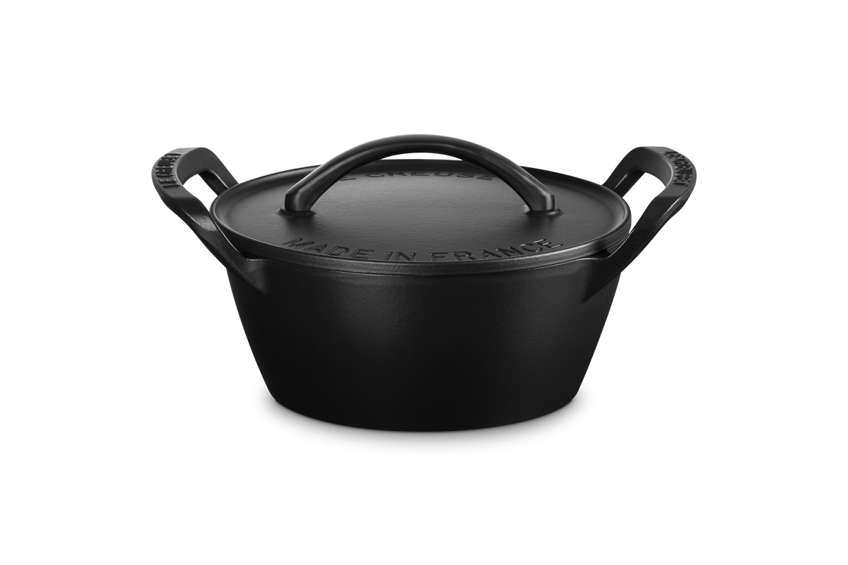 Three quarter view of Alpine Outdoor 4.25 qt Round Dutch Oven in Matte Black showcasing domed lid and loop handles on white background