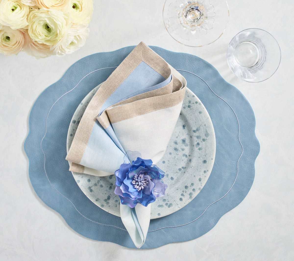 Top view of Tailored Placemats in Periwinkle Set of 4 showcasing wavy edges and embroidered borders beneath a styled place setting