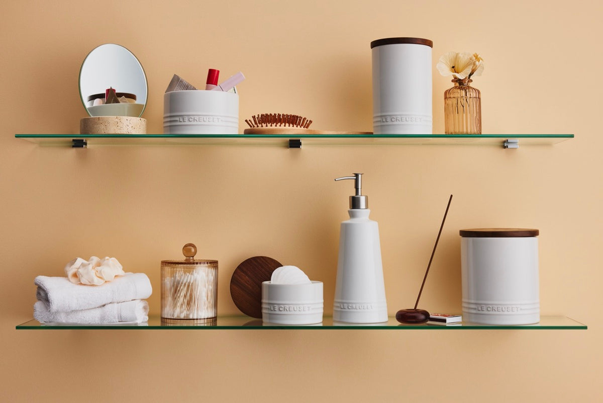 Front view of Signature Storage Canister 16 oz in white with wood lid and embossed logo on glass shelf