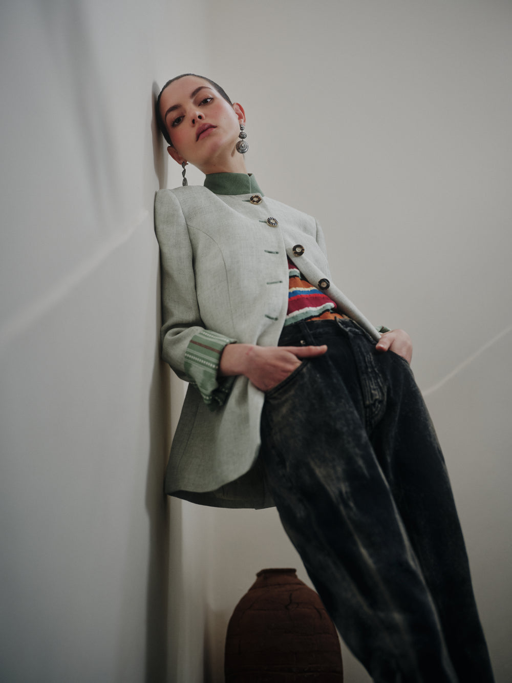 Low-angle view of Louise Gris grey linen jacket on model showing longer silhouette, horn buttons, and green trim
