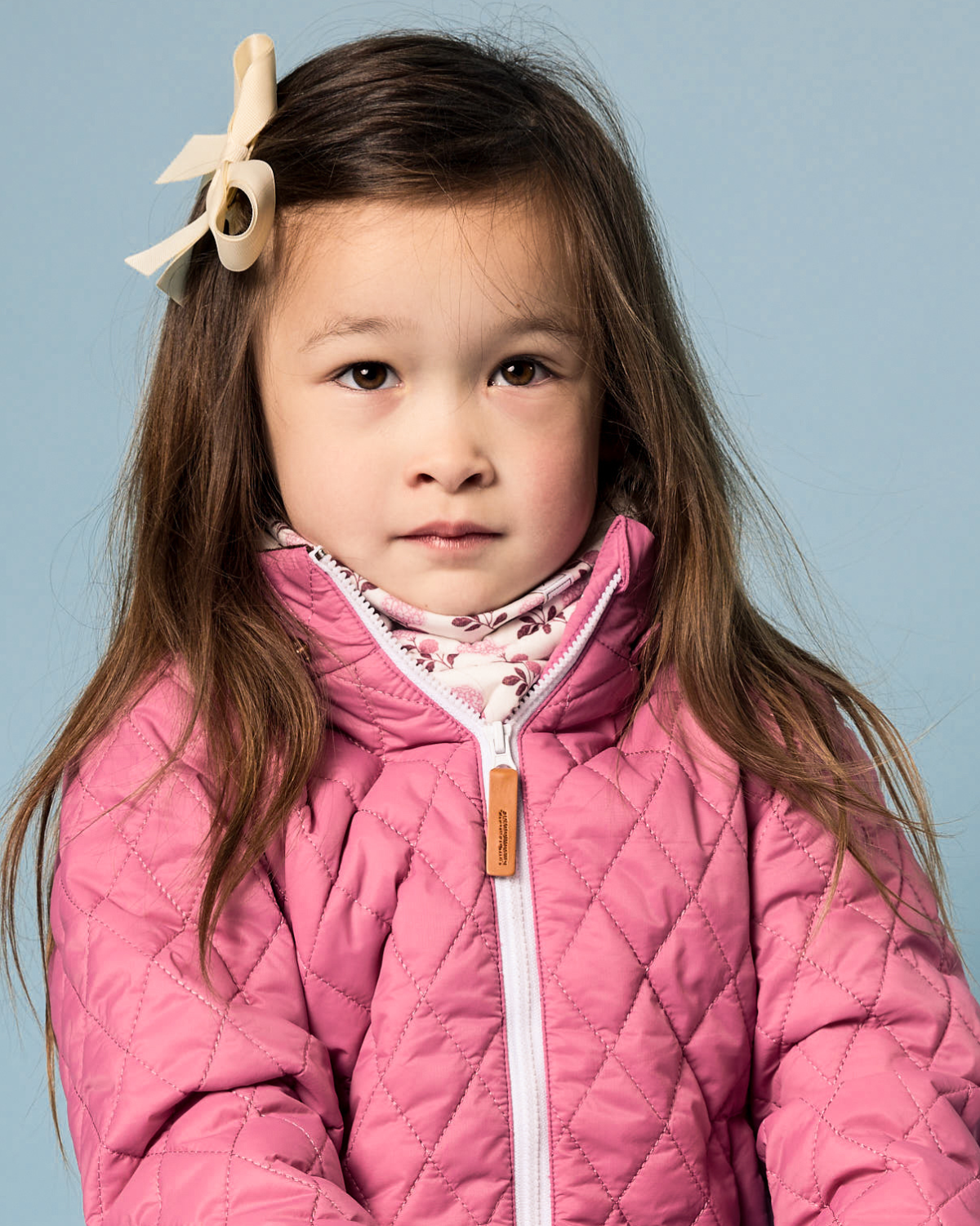 Front view of Pink Hydrangea Fleece-Lined Neck Warmer showcasing floral details on a child against a blue background
