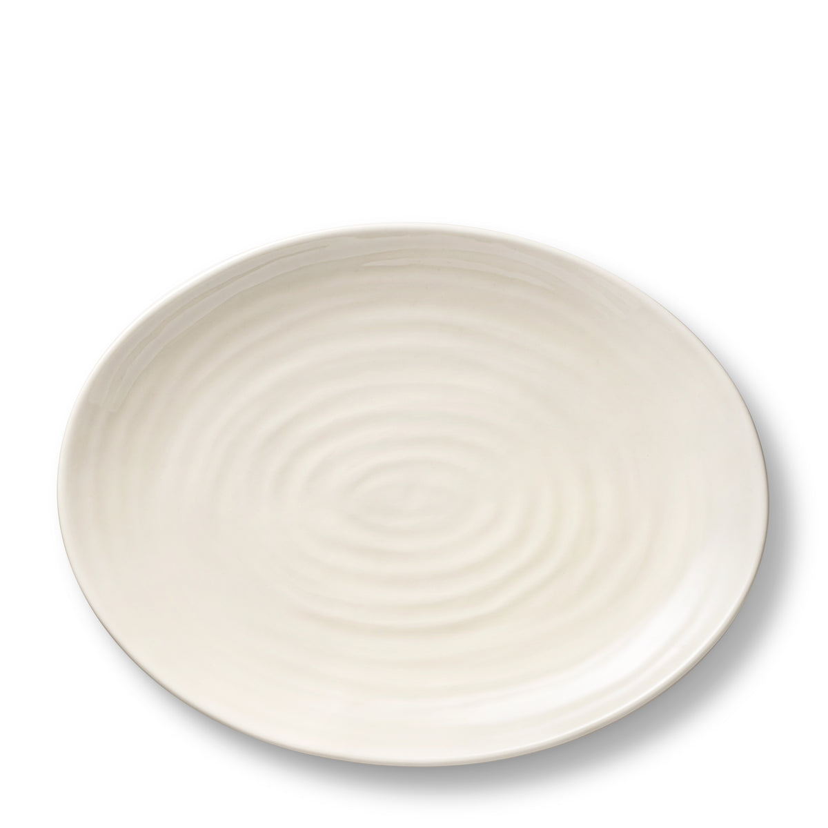 Close-up view of Allette Pedestal Oval Platter in Cream showcasing delicate ribbing on a white background